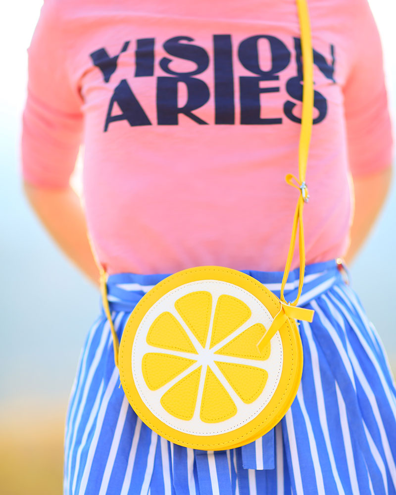 Colorful fashion blogger Kelly Golightly wearing cute Feiyue sneakers + pink shirt paired with blue-and-white striped skirt + lemon bag. #kellygolightly #jcrew #feiyue #stripes #lemons #lemonbag #lemonhandbag