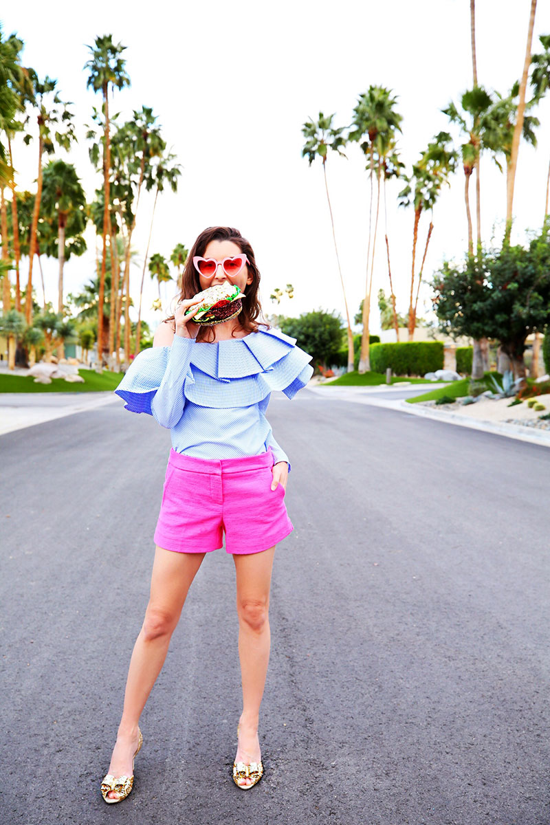 Glitter Bags | Love this blue ruffle top paired with pink shorts and a glitter bag and sparkly glitter heels. As seen on fashion blogger Kelly Golightly in Palm Springs.