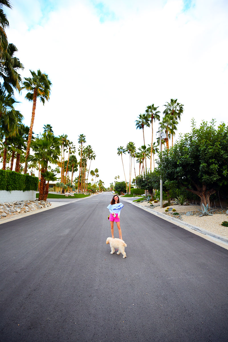 Love this blue ruffle top paired with pink shorts and a glitter bag and sparkly glitter heels. As seen on fashion blogger Kelly Golightly in Palm Springs.